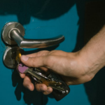 A person unlocking the door using keys