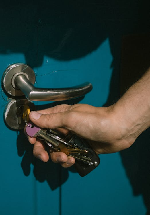 A person unlocking the door using keys