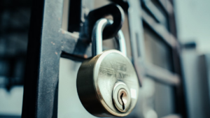 Steel padlock securing a metal gate